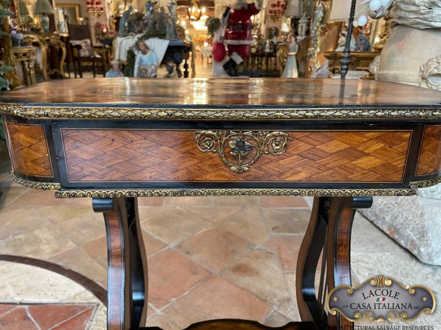 <h2>Tavolino antico da lavoro.</h2>
<p><em>Tavolino antico da lavoro</em> con gamba a lira; intarsi con legni pregiati e bronzi a rilievo. Epoca primi 1800.</p>