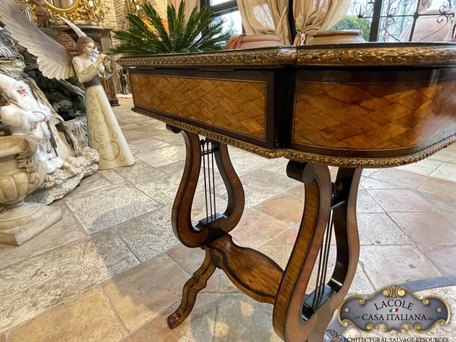 <h2>Tavolino antico da lavoro.</h2>
<p><em>Tavolino antico da lavoro</em> con gamba a lira; intarsi con legni pregiati e bronzi a rilievo. Epoca primi 1800.</p>