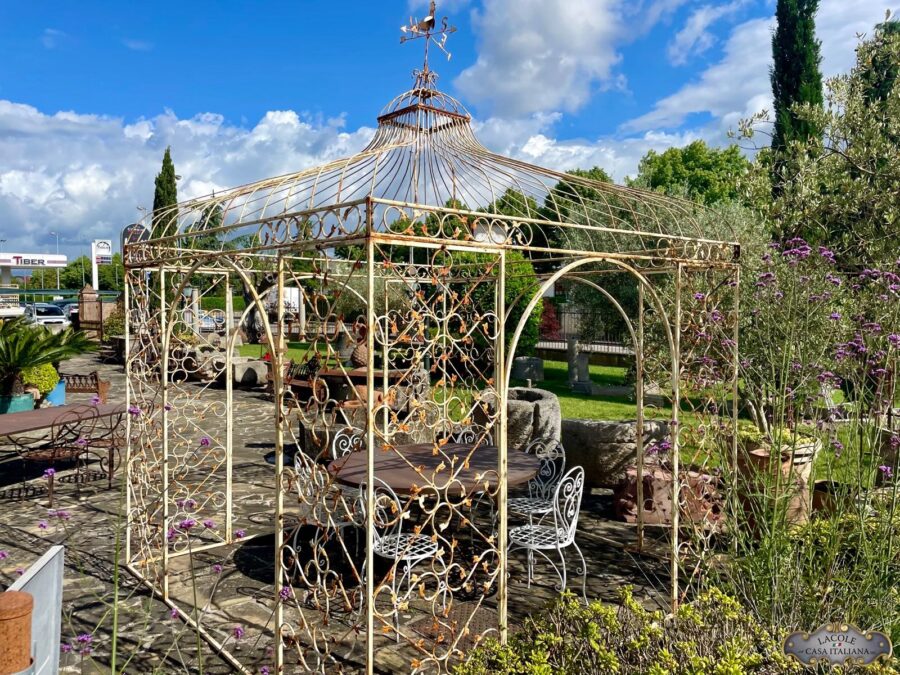 Handcrafted white iron gazebo, beautiful floral decorations and arched openings.